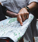 Close up of man's hand pointing to point on map with index finger