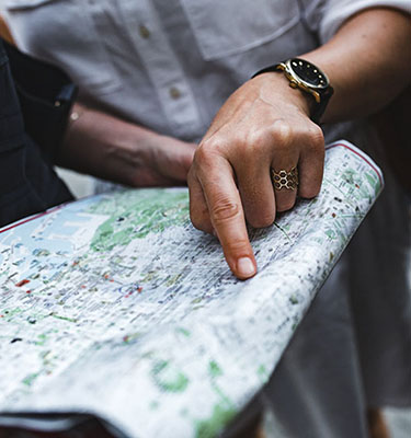 Hand pointing to place on map as another person holds the map