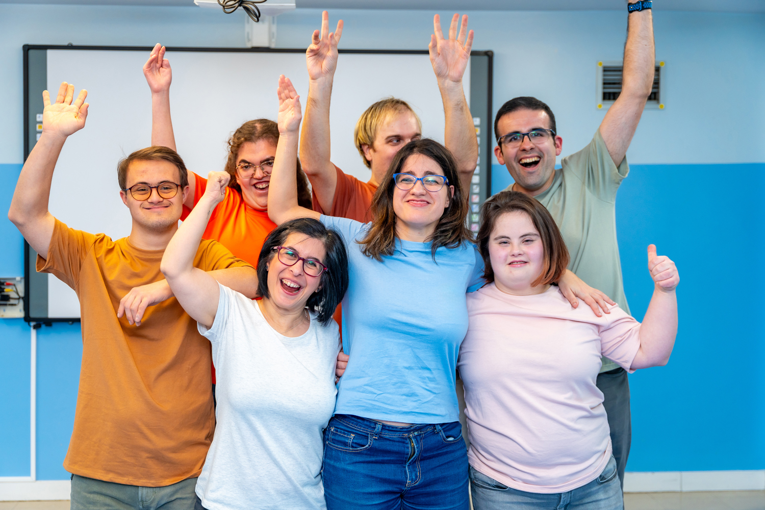 group of individuals with disabilities smiling and waving